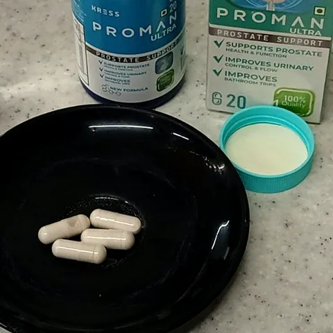 Five Proman Ultra capsules on a black saucer with the bottle cap beside them